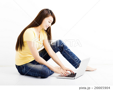 Smiling seated young woman with laptop 26665904