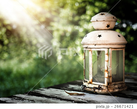 White broken lantern on an old wooden table. 26671421