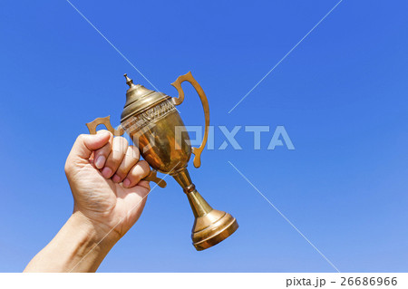 Holding the cup with blue sky background. 26686966