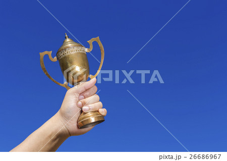 Holding the cup with blue sky background. 26686967