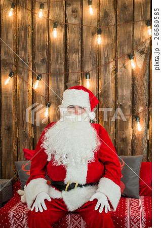 Traditional Santa Claus sitting on the couch and Traditional Santa Claus sitting on the couch and 26689585