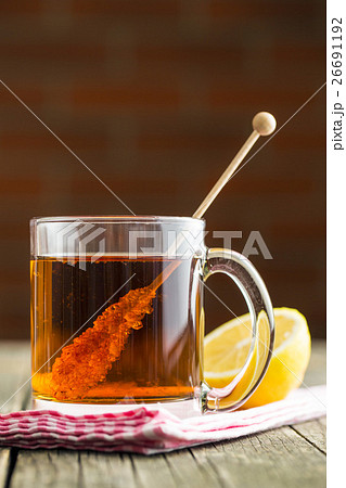 Tea cup with sugar crystal on wooden stick. 26691192