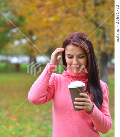 woman in autumn outdoors with cup of coffee woman in autumn outdoors with cup of coffee 26691722