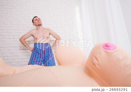 Man stay near the bed with inflatable sex doll. Man stay near the bed with inflatable sex doll. 26693291