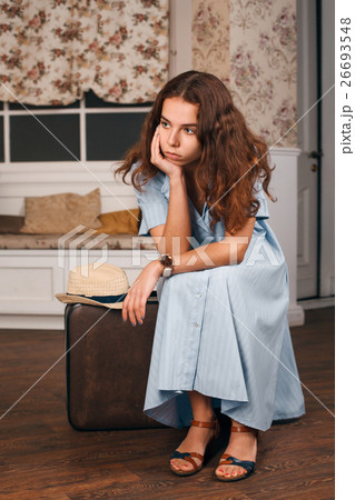 Travelling concept with woman sitting on suitcase 26693548