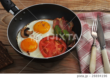 bacon and eggs and mushrooms with the pan 26694196