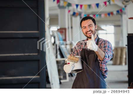 Handyman using brush in his workshop with thumb up Handyman using brush in his workshop with thumb up 26694945