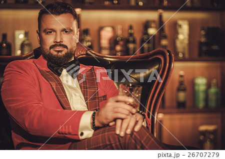 Extravagant stylish man with whisky glass sitting Extravagant stylish man with whisky glass sitting 26707279