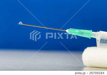 Syringe on gauze with drop on top of needle 26709384