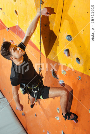 Dexterous man spending day in climbing gym 26711619