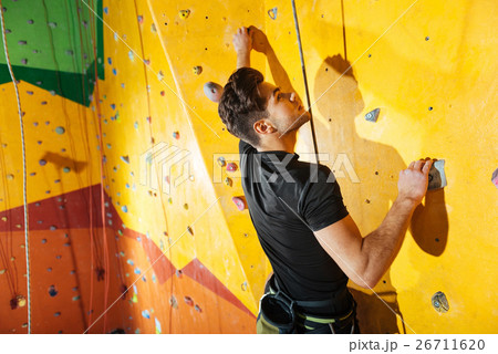 Enthusiastic man spending time in climbing gym. 26711620
