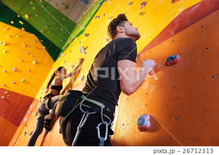 Delighted couple climbing up the wall. 26712313