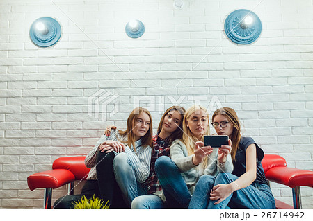 Beautiful girls sitting on the couch, have fun and 26714942