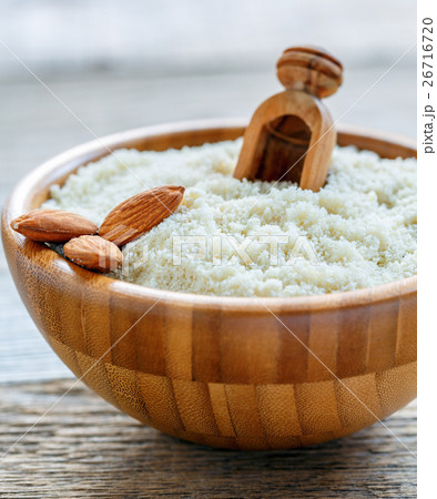 Bowl with almond flour and a wooden scoop. Bowl with almond flour and a wooden scoop. 26716720