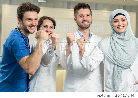 attractive male doctor in front of medical group attractive male doctor in front of medical group 26717644