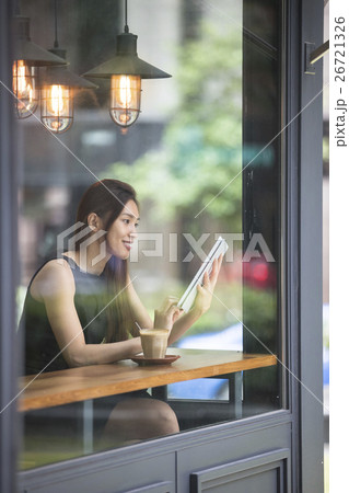 Asian Businesswoman reading her tablet computer in a cafe. 26721326