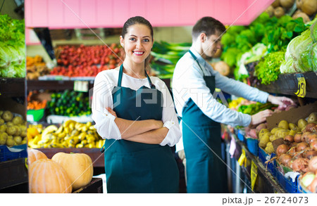 Smiling positive sellers having vegetables and fruits on displays 26724073