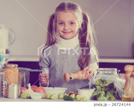 Smiling little girl learning to cook in kitchen 26724144