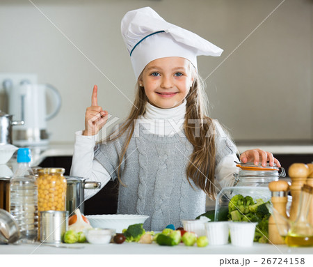 Sweet little girl in cook cap with sprouts and broccoli 26724158