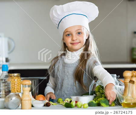 Sweet little girl in cook cap with sprouts and broccoli 26724175