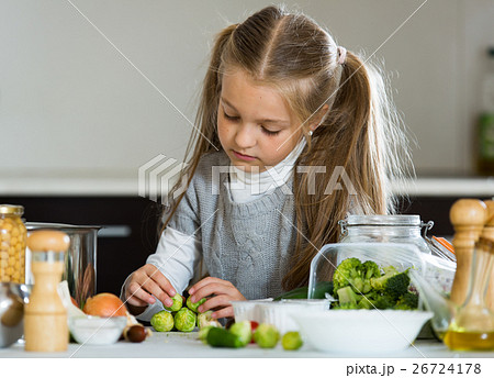 Cute little girl cooking veggies in kitchen 26724178