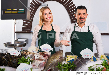 Positive smiling shop assistants selling fresh fish 26724760