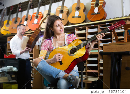 Couple playing guitars in music shop. Couple playing guitars in music shop. 26725104