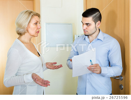 Serious man and housewife at the door 26725596
