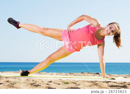 Woman doing yoga at beach 26725623