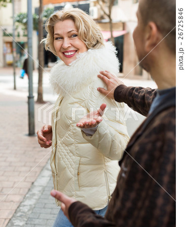 Senior man flirting with smiling pleasant blonde woman Senior man flirting with smiling pleasant blonde woman 26725846