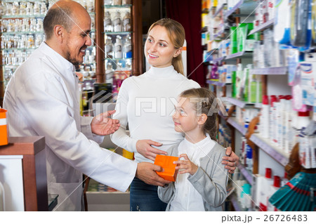 Mature male pharmacist helping customers 26726483