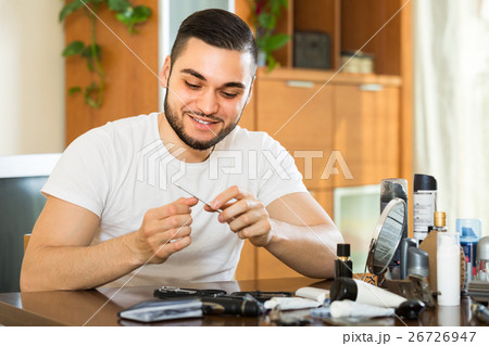 Man doing manicure at home 26726947