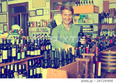 customer picking bottle in wine store. 26726986