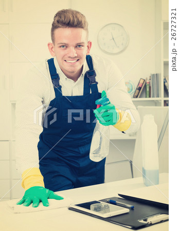 Handsome guy in uniform cleaning in office 26727321