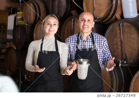 Smiling mature man and young woman posing with wine from wood 26727349