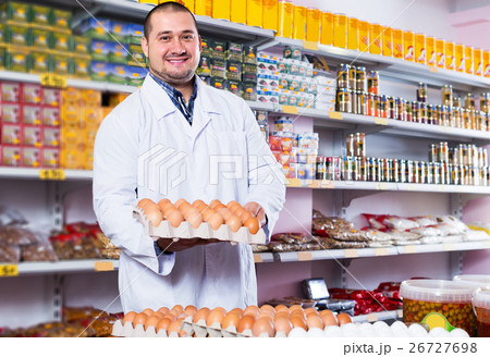 Seller posing with dozens of eggs 26727698