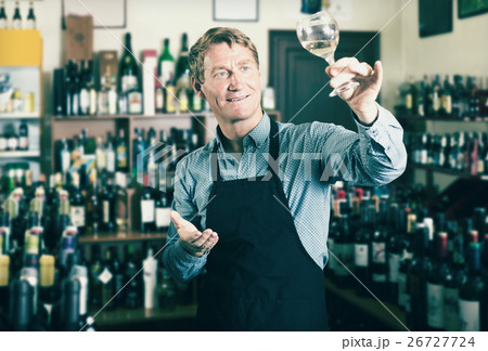 Male seller promoting to try wine before purchasing Male seller promoting to try wine before purchasing 26727724