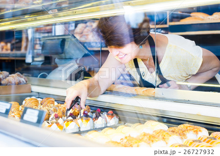 female baker offering fresh pastry 26727932