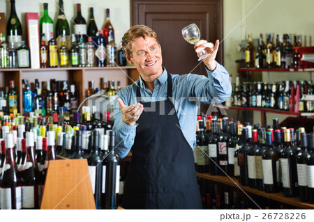 Man working in wine house holding glass of wine for tasting 26728226