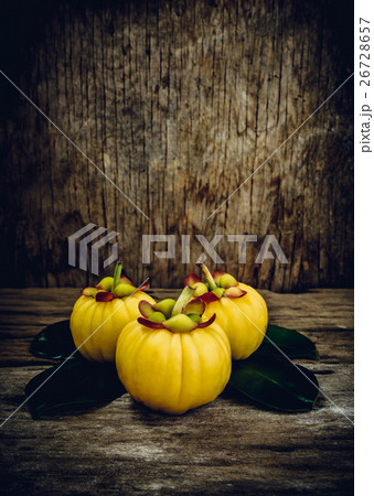 Garcinia cambogia fresh fruit on wood background. Garcinia cambogia fresh fruit on wood background. 26728657