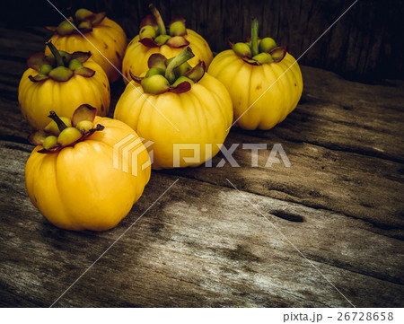 Garcinia cambogia fresh fruit on wood background. 26728658