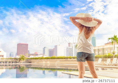 Young woman enjoying her vacation beside the pool Young woman enjoying her vacation beside the pool 26737111