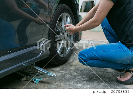 Female driver changing tyre on her broken car. Female driver changing tyre on her broken car. 26738355