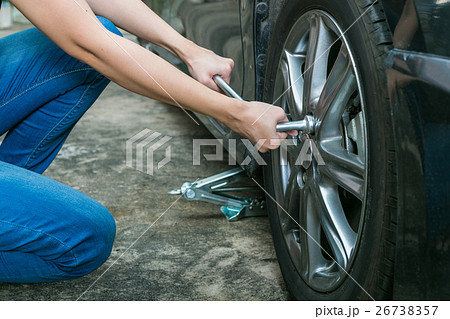Female driver changing tyre on her broken car. Female driver changing tyre on her broken car. 26738357