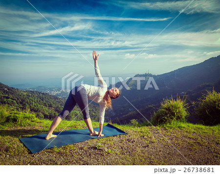 Woman doing Ashtanga Vinyasa yoga asana Parivrtta 26738681