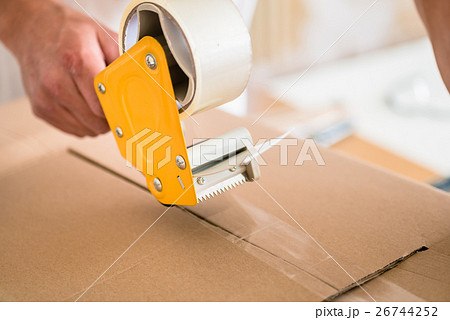 Man taping packing case 26744252