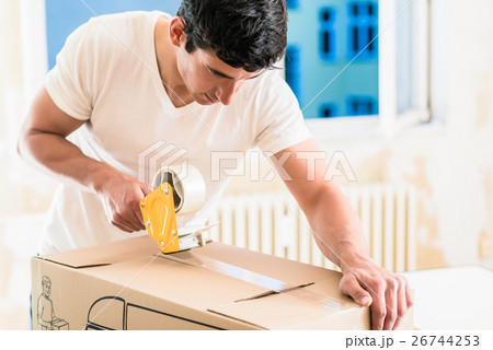 Man or handyman taping packing case 26744253