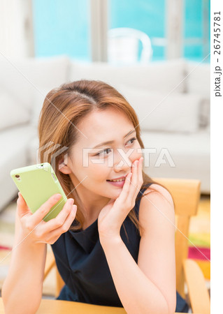 部屋でスマホを見る女性 26745781