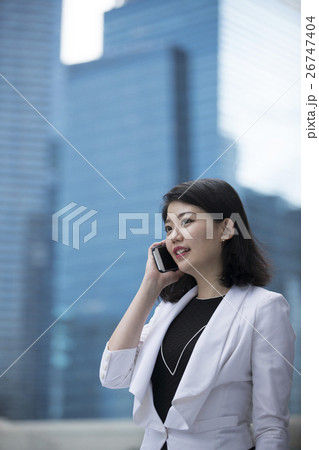 Asian businesswoman talking on smart phone. Asian businesswoman talking on smart phone. 26747404