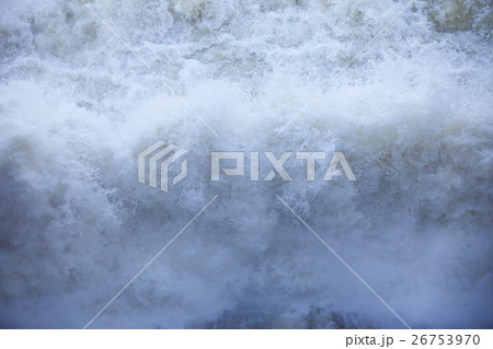 Water flowing from the open sluice gates of dam. 26753970